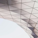 Abstract architectural detail showcasing a geometric pattern with triangles under natural light.